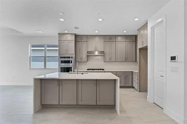 a kitchen with kitchen island a sink stainless steel appliances and cabinets