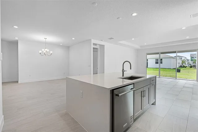 a view of a kitchen with a sink and chandelier