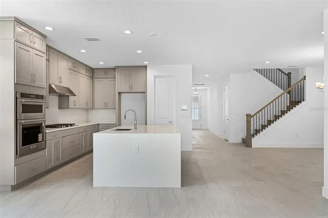 a large kitchen with stainless steel appliances granite countertop a stove a sink and a refrigerator