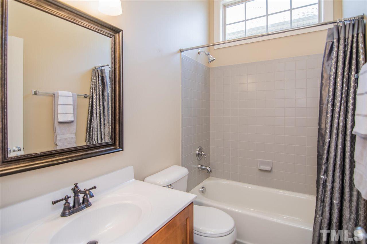 8214 Cushing Street Raleigh, NC 27613 - Photo 14 of 30 a bathroom with a sink mirror toilet and bathtub