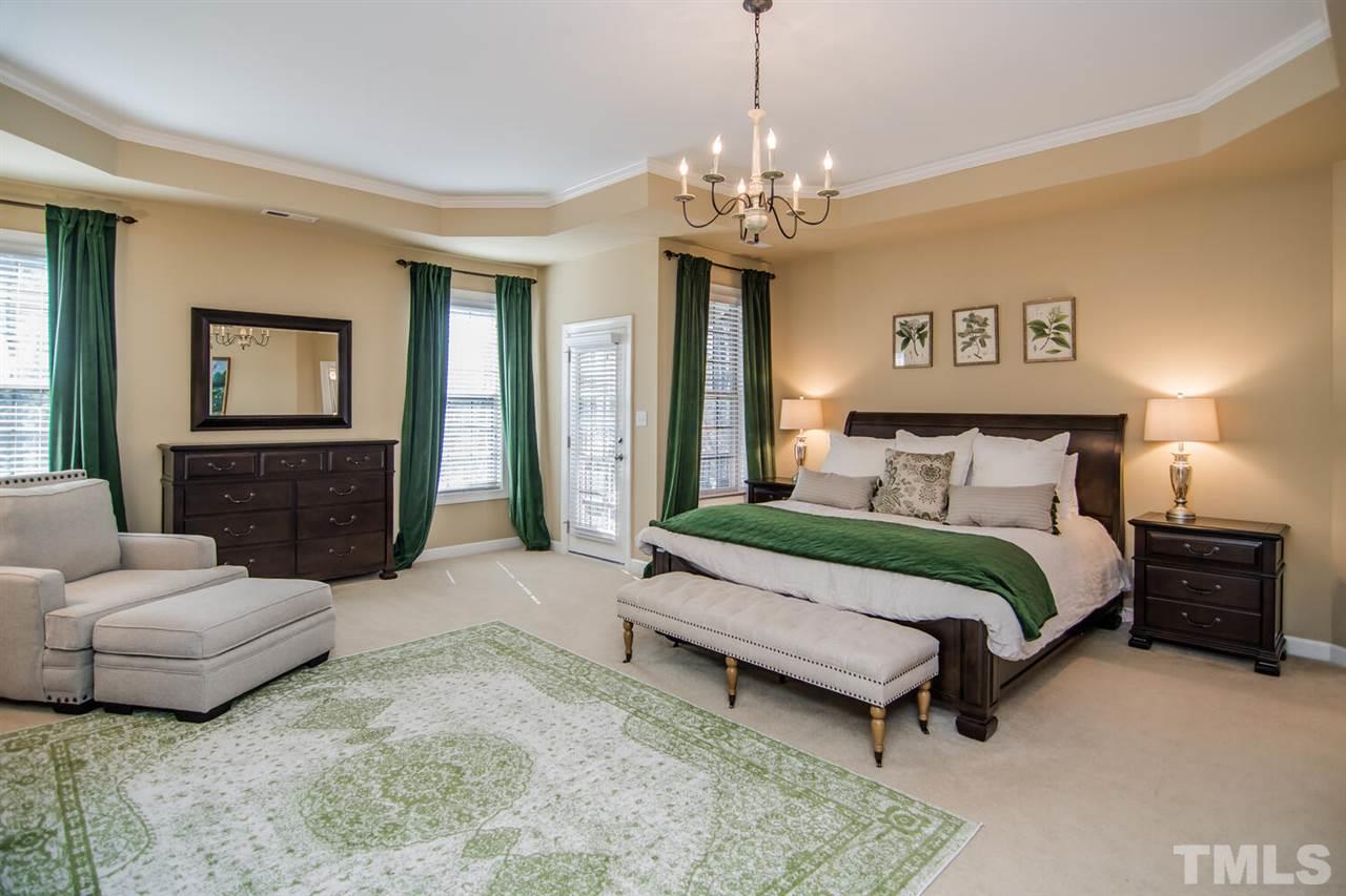 8214 Cushing Street Raleigh, NC 27613 - Photo 15 of 30 a spacious bedroom with a bed a couch and dresser