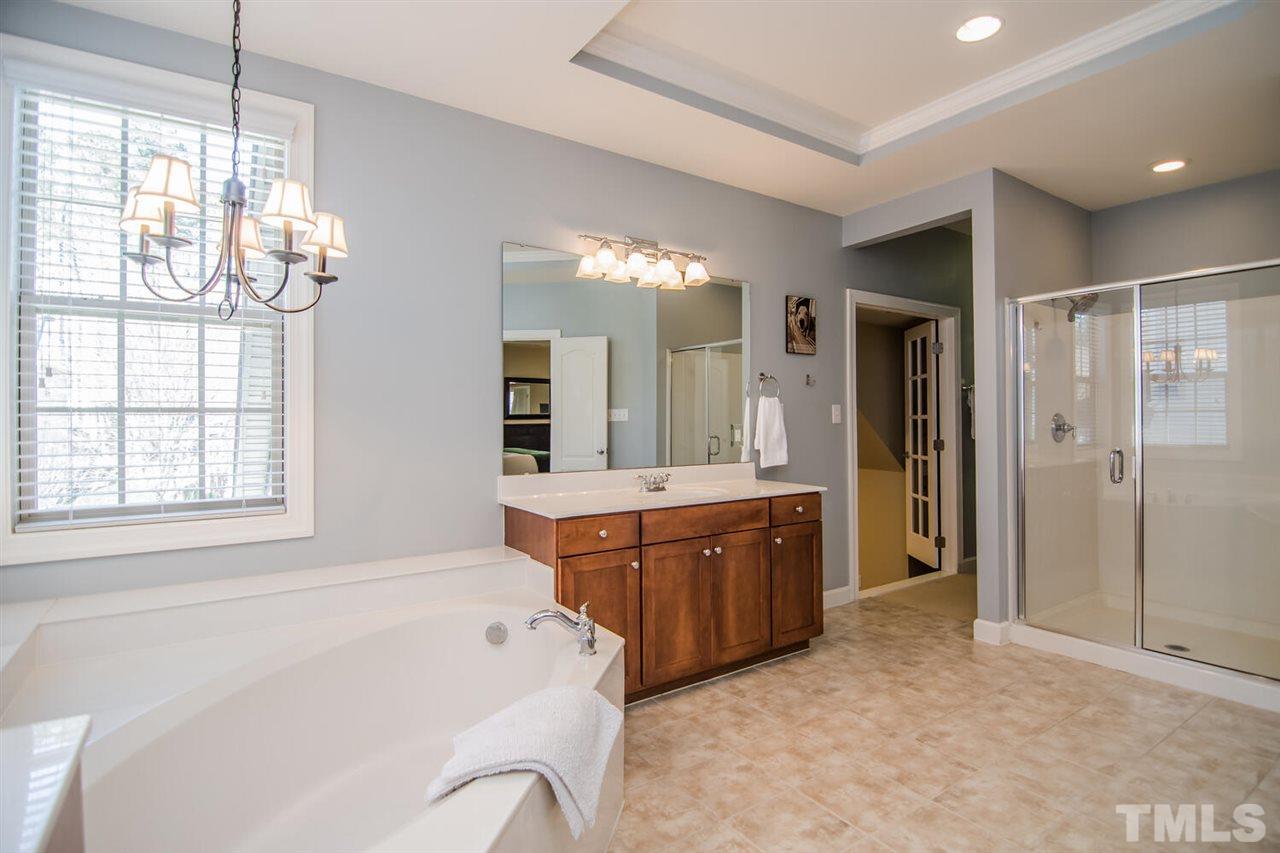8214 Cushing Street Raleigh, NC 27613 - Photo 19 of 30 a large bathroom with a tub sink shower and mirror