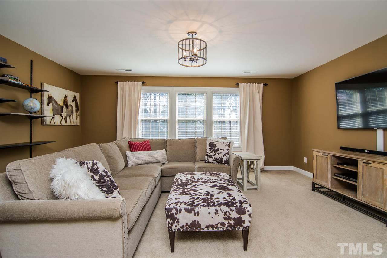 8214 Cushing Street Raleigh, NC 27613 - Photo 22 of 30 a bedroom with furniture and a flat screen tv