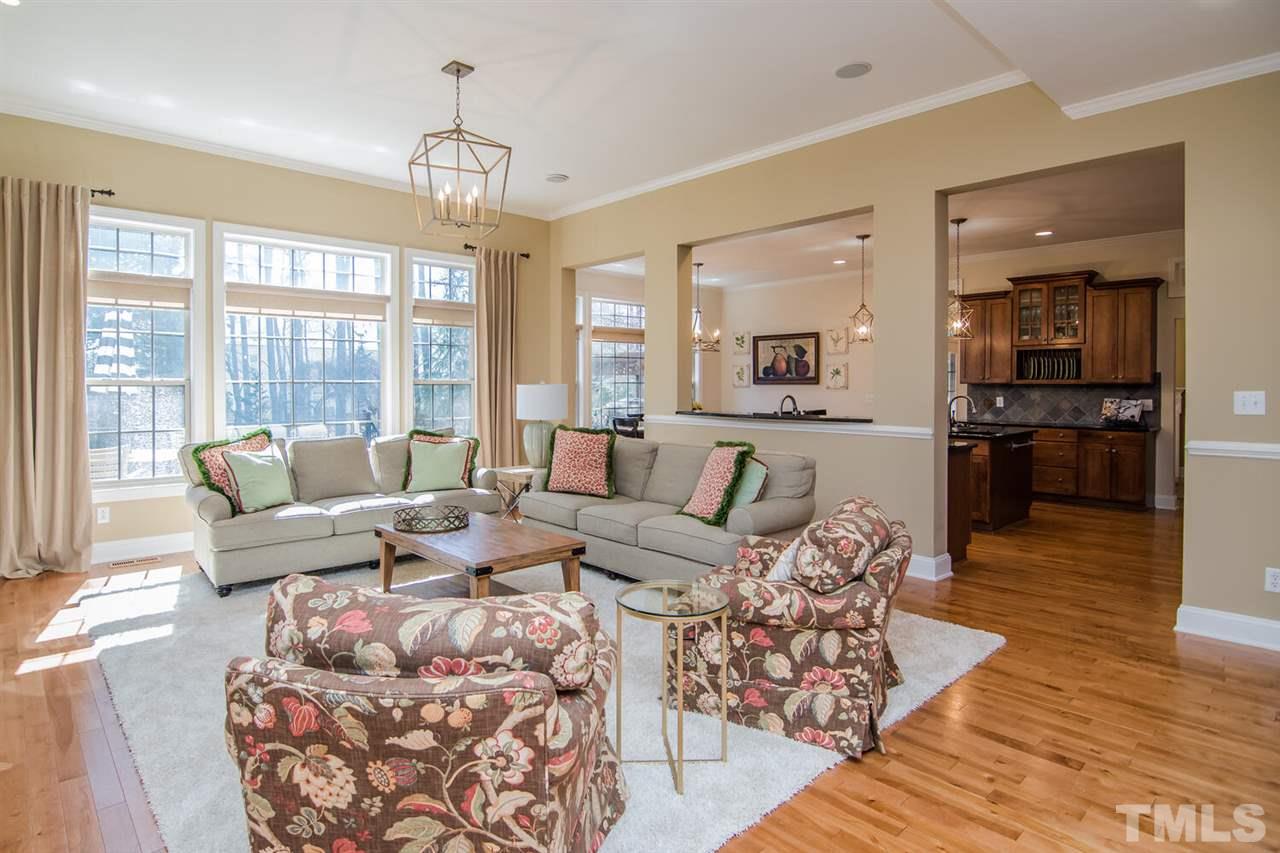 8214 Cushing Street Raleigh, NC 27613 - Photo 6 of 30 a living room with furniture windows and a chandelier