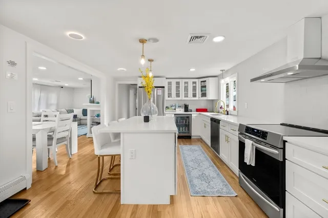 a kitchen with white cabinets and stainless steel appliances