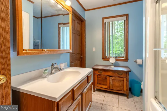 a bedroom with a bed mirror and window