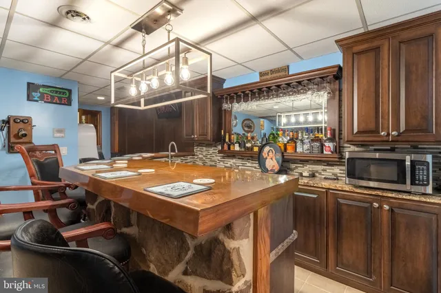 a kitchen with stainless steel appliances granite countertop a sink a stove and a wooden cabinets