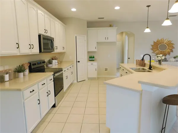 a kitchen with stainless steel appliances a sink a stove a refrigerator and cabinets