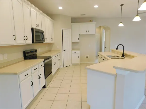 a kitchen with stainless steel appliances a sink a stove a refrigerator and cabinets