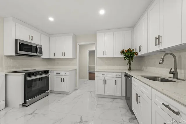 a kitchen with granite countertop a stove and a microwave