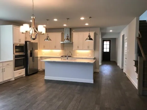 a view of kitchen with refrigerator microwave and stove