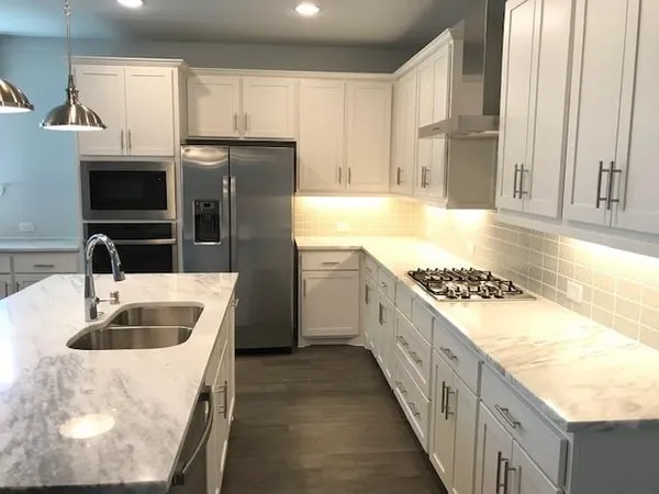 a kitchen with stainless steel appliances granite countertop a sink stove and refrigerator