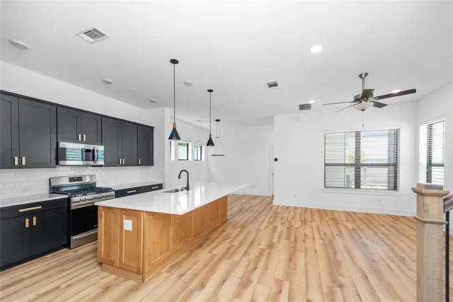 a kitchen with stainless steel appliances granite countertop a sink a stove and a refrigerator