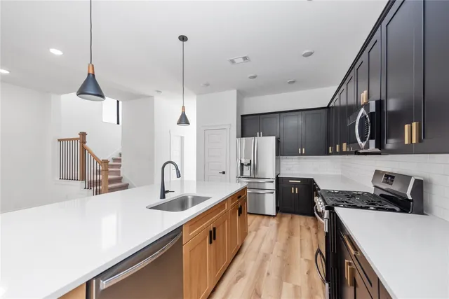 a kitchen with stainless steel appliances a sink stove and refrigerator