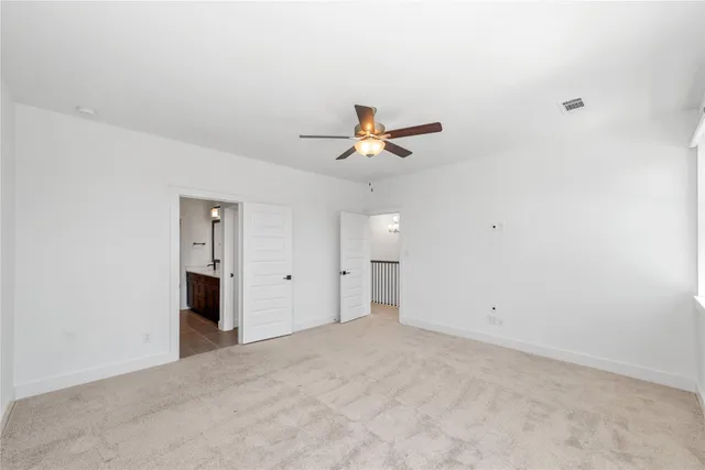 an empty room with closet and a ceiling fan
