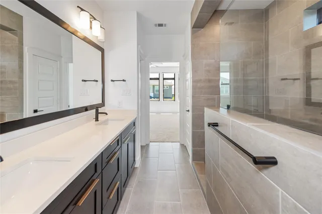a bathroom with a granite countertop sink a mirror and a bathtub