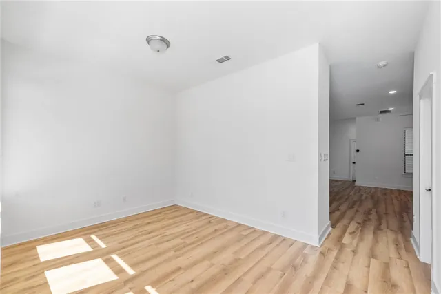 a view of a room with wooden floor and a bathroom