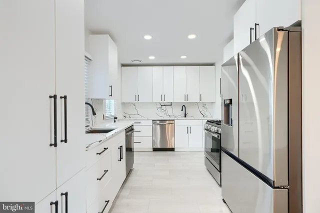 a kitchen with white cabinets and stainless steel appliances
