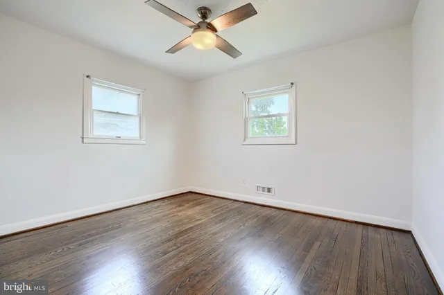 a view of room with wooden floor and ceiling fan