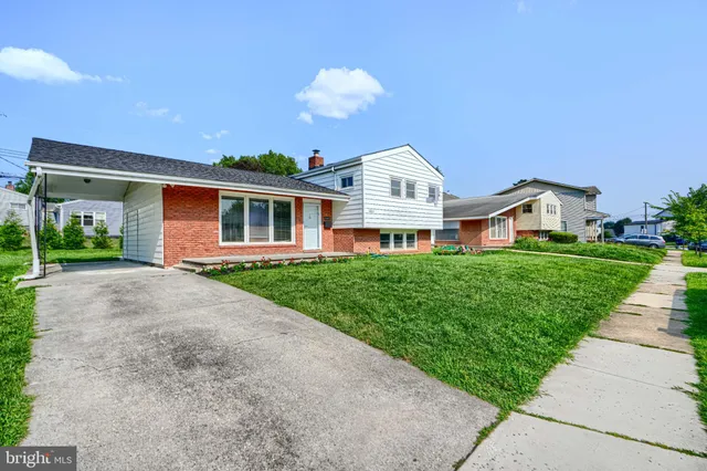 a front view of a house with a yard and potted plants