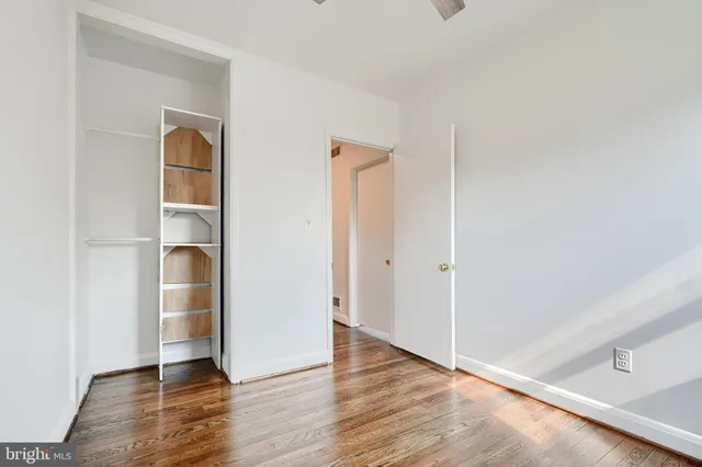 a view of empty room with wooden floor and closet