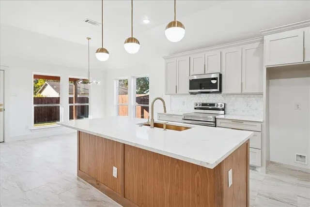 a kitchen with microwave a stove and a sink