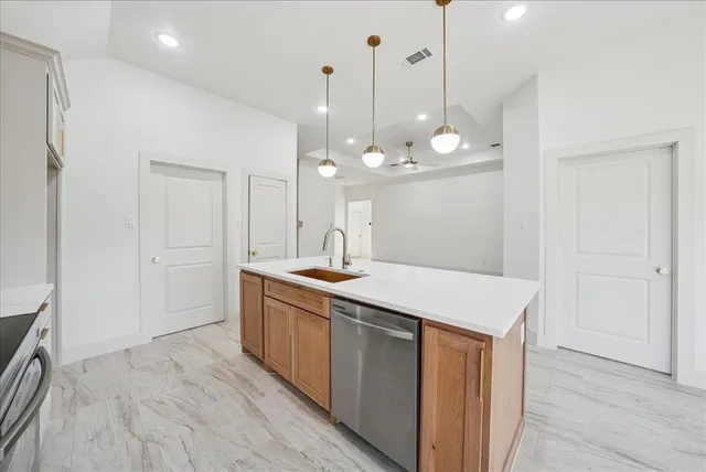 a room with kitchen island a sink and wooden floor