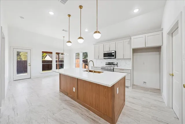 a kitchen with stove a sink and a refrigerator
