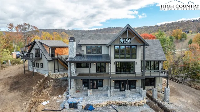 a front view of a house with a big yard and potted plants