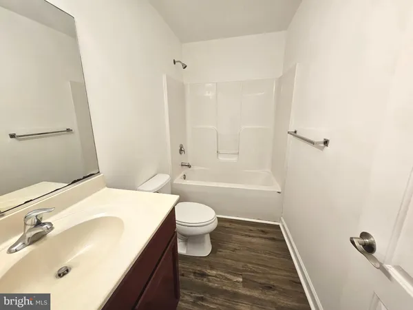 a bathroom with a granite countertop toilet sink and mirror