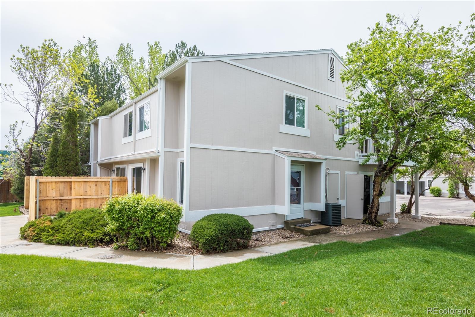 a view of an house with backyard and a tree