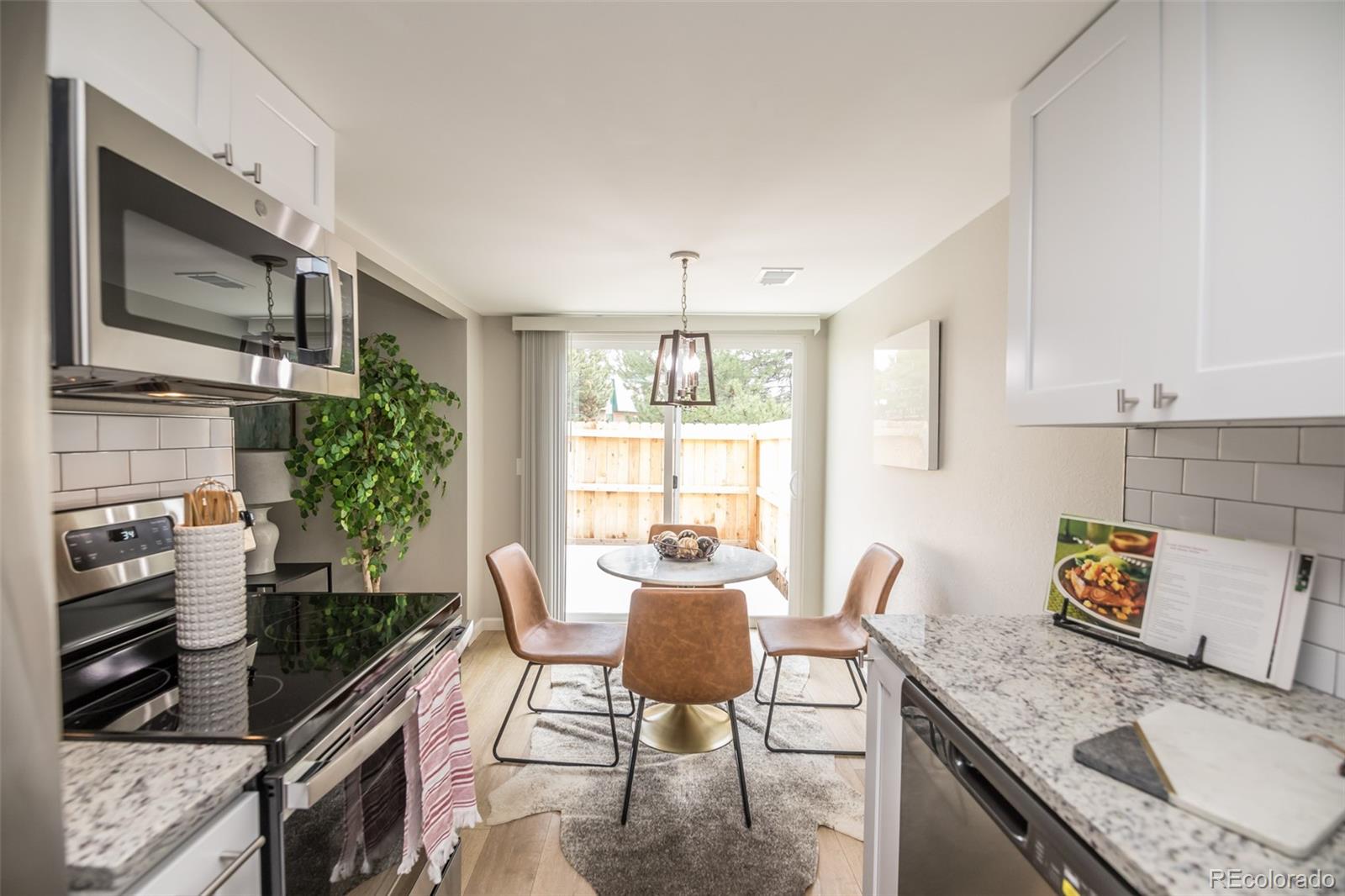 7906 Chase Circle, Unit 143 Arvada, CO 80003 - Photo 11 of 38 a dining room with furniture a window and a kitchen view