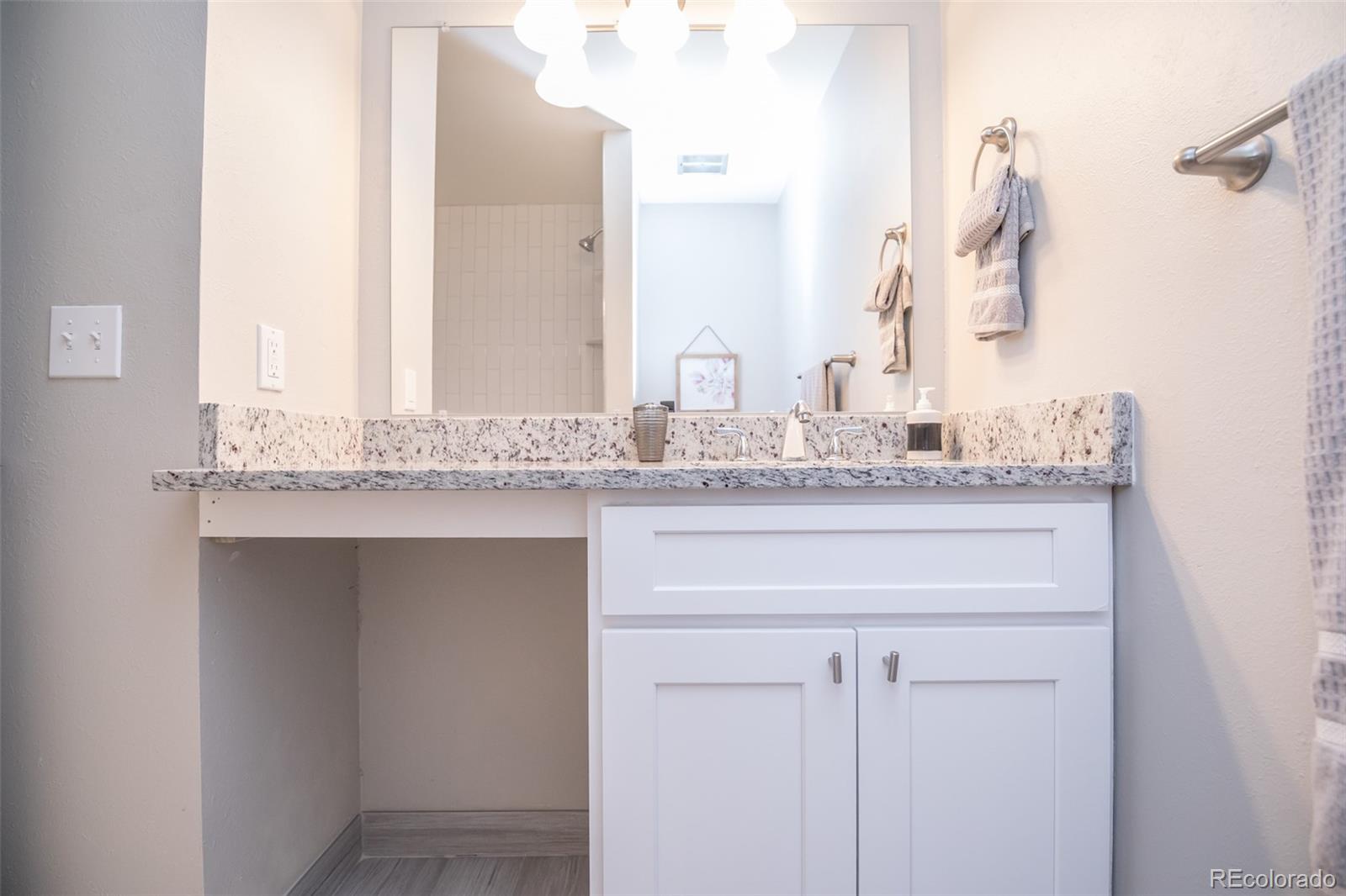 7906 Chase Circle, Unit 143 Arvada, CO 80003 - Photo 19 of 38 a bathroom with a granite countertop sink and a mirror