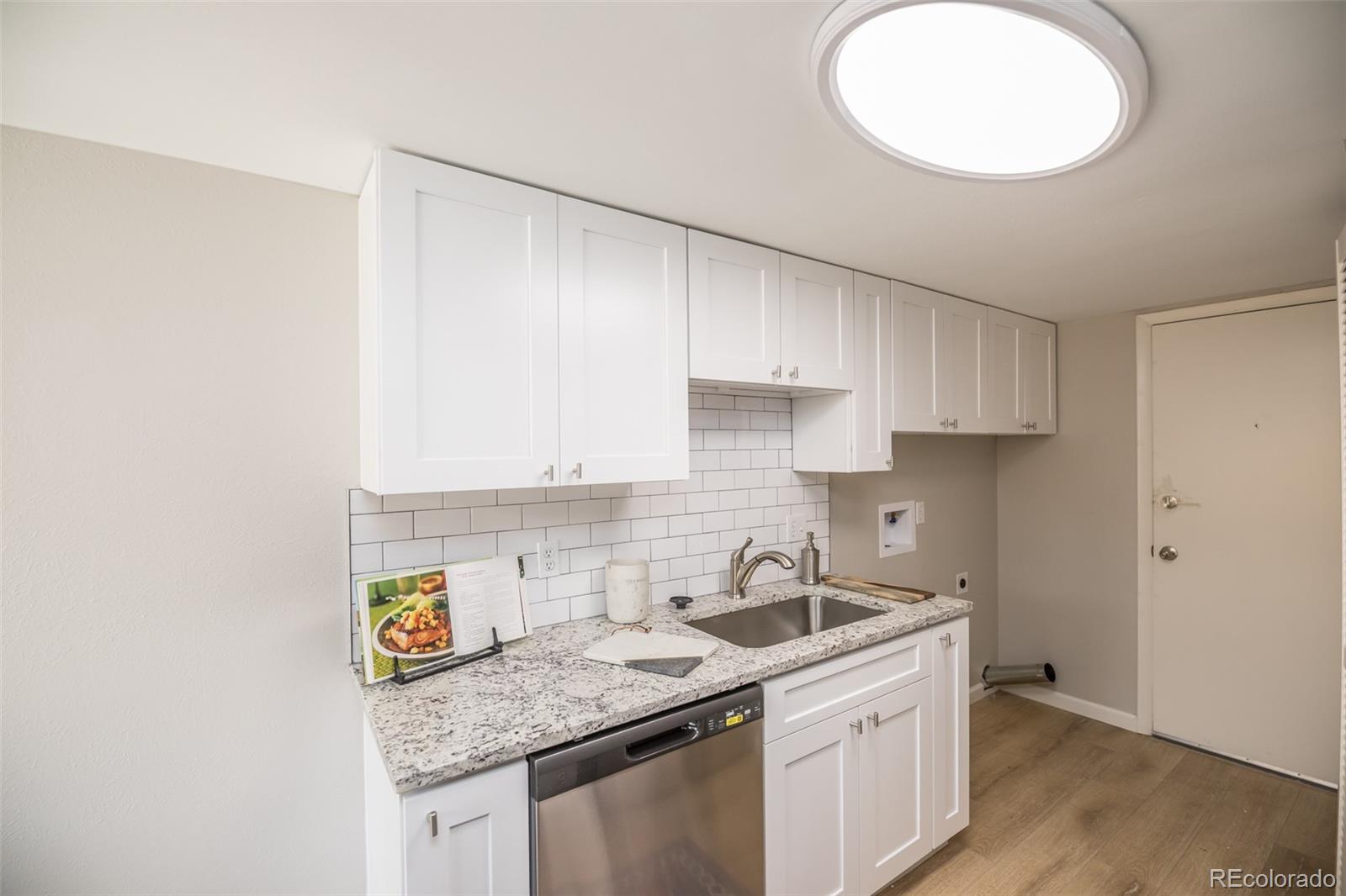 7906 Chase Circle, Unit 143 Arvada, CO 80003 - Photo 8 of 38 a kitchen with stainless steel appliances granite countertop a sink a stove and a white cabinets