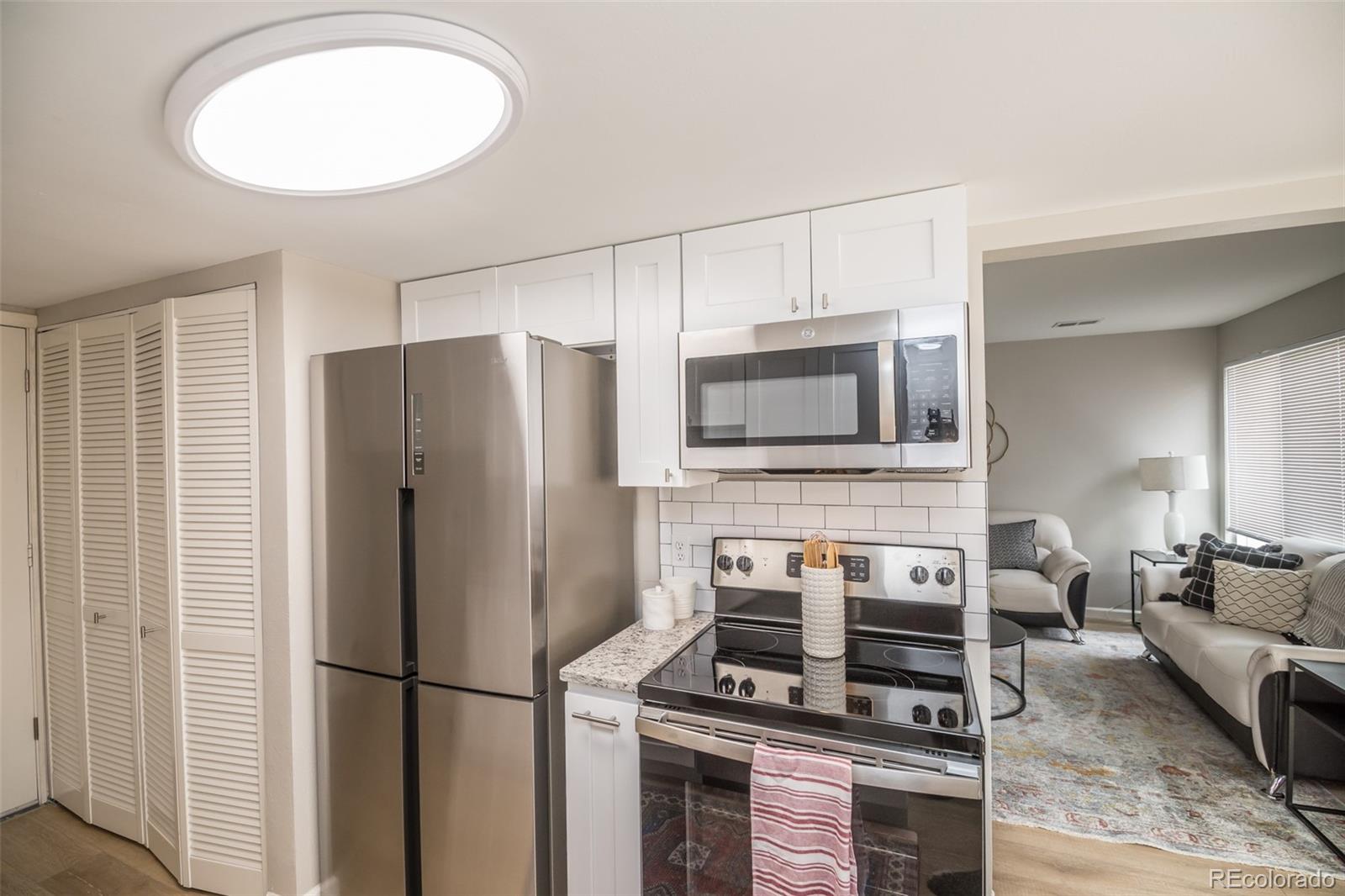 7906 Chase Circle, Unit 143 Arvada, CO 80003 - Photo 9 of 38 a kitchen with stainless steel appliances a refrigerator stove and microwave