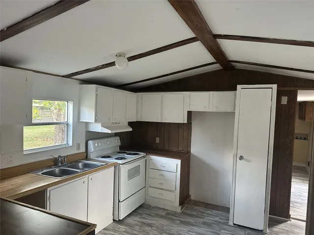 a kitchen with a sink cabinets stainless steel appliances and a window