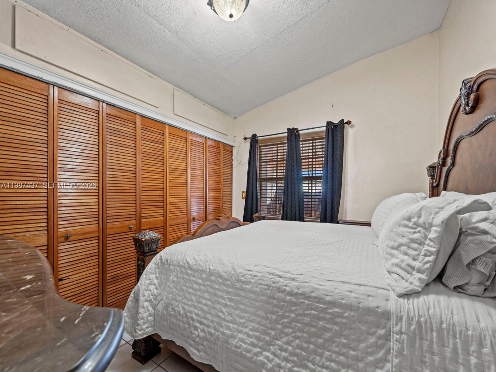 871 Southeast 5th Place Hialeah, FL 33010 - Photo 23 of 39 a bedroom with a bed and a large window