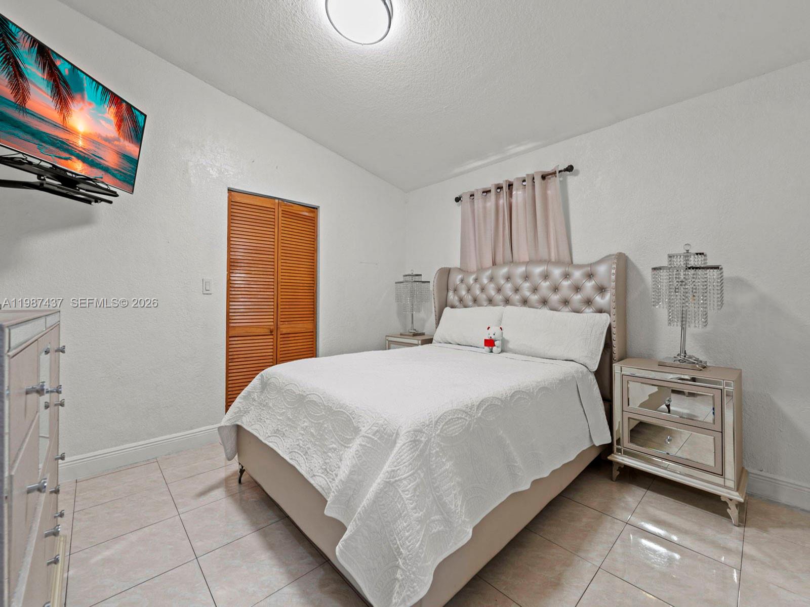 871 Southeast 5th Place Hialeah, FL 33010 - Photo 26 of 39 a bedroom with a bed and a flat screen tv