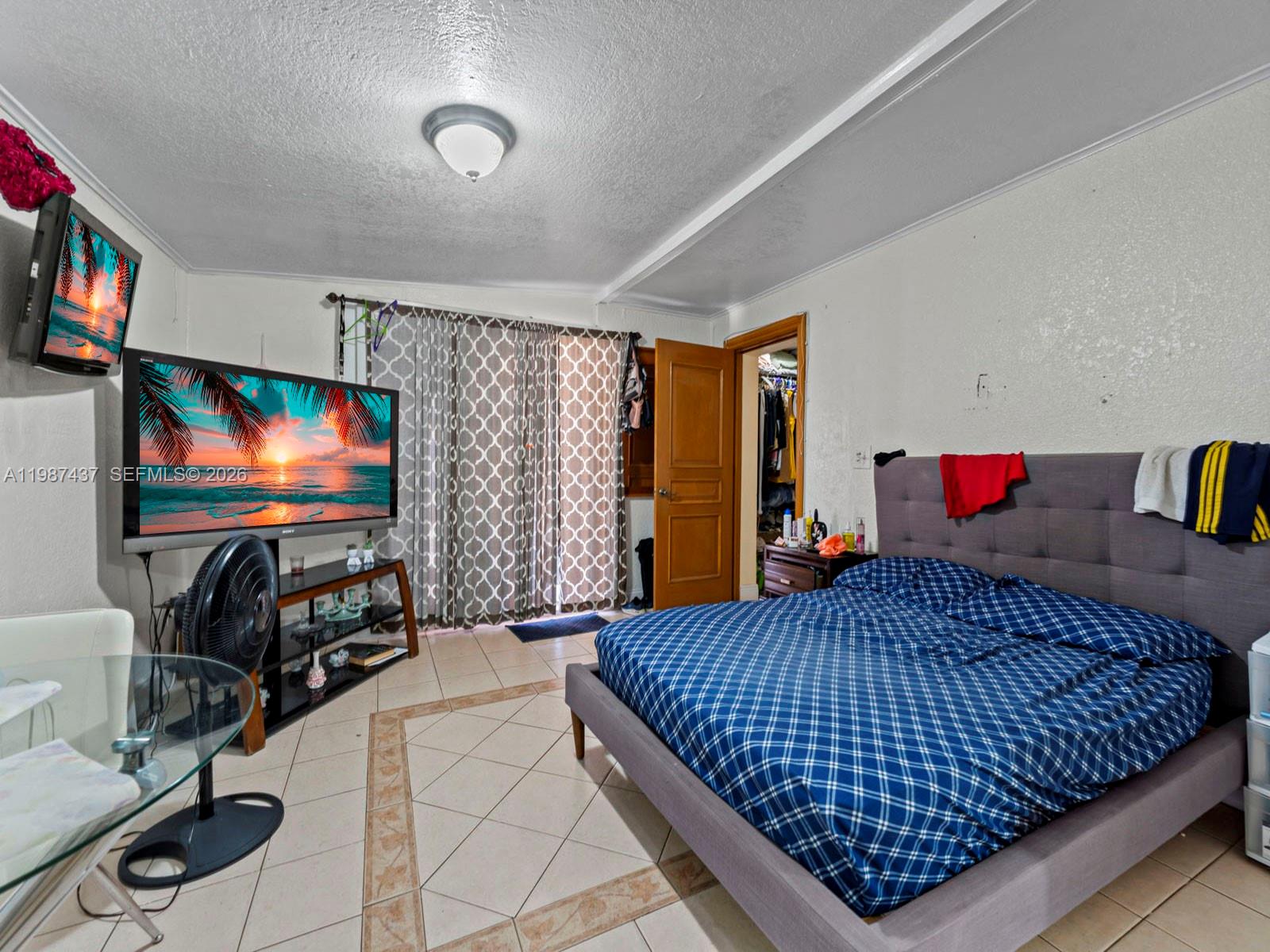 871 Southeast 5th Place Hialeah, FL 33010 - Photo 28 of 39 a bedroom with a bed and a flat screen tv