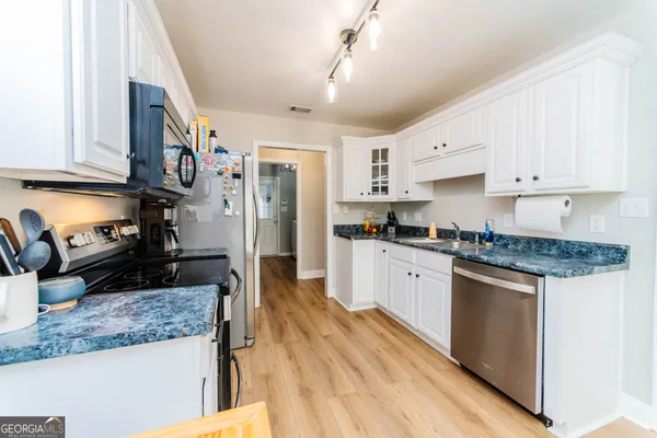 a kitchen with stainless steel appliances granite countertop a refrigerator a stove and a sink