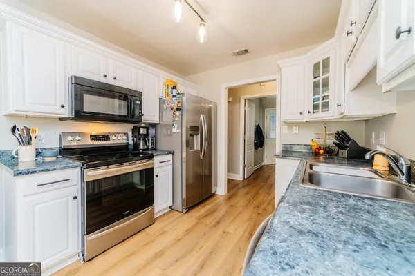 a kitchen with granite countertop a stove a sink and a microwave
