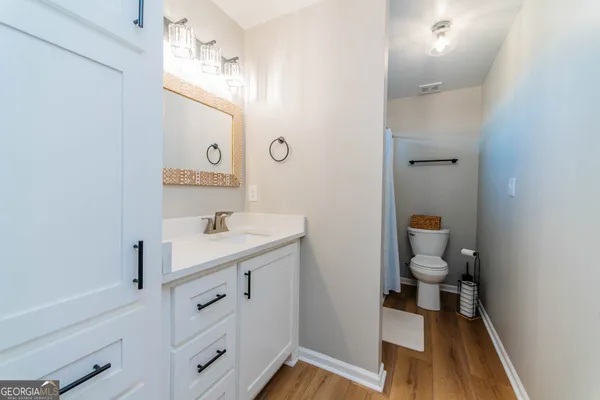 a bathroom with a sink a toilet and a mirror