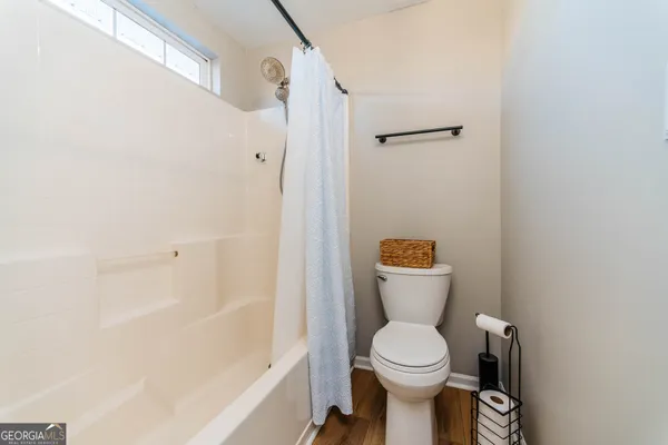 a white toilet sitting next to a bathroom sink and a shower