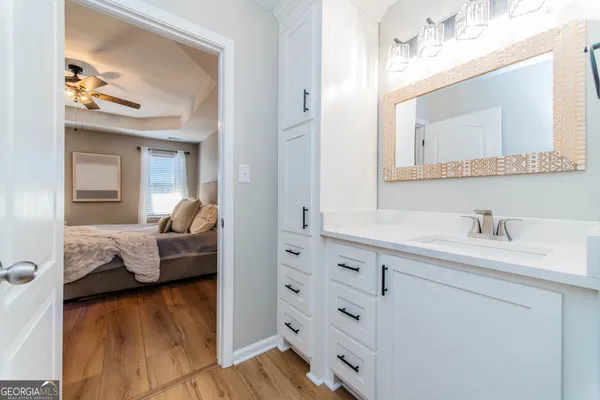 a en suite bathroom with a granite countertop sink and mirror