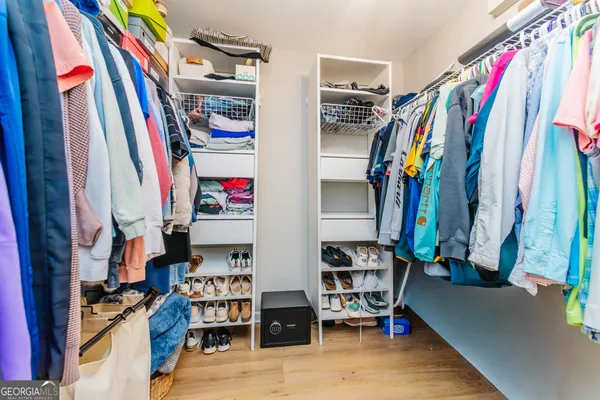 a view of walk in closet with clothes and shoes