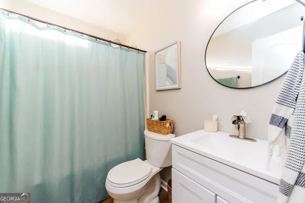 a bathroom with a sink mirror vanity and toilet