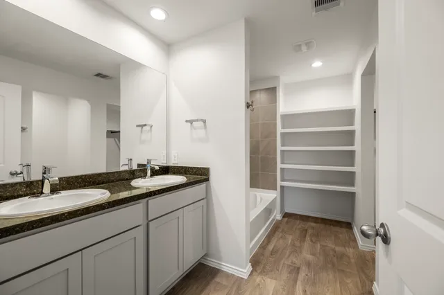 a bathroom with a granite countertop sink a toilet and a mirror