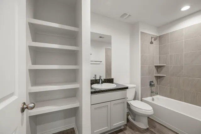 a bathroom with a sink a toilet and shower