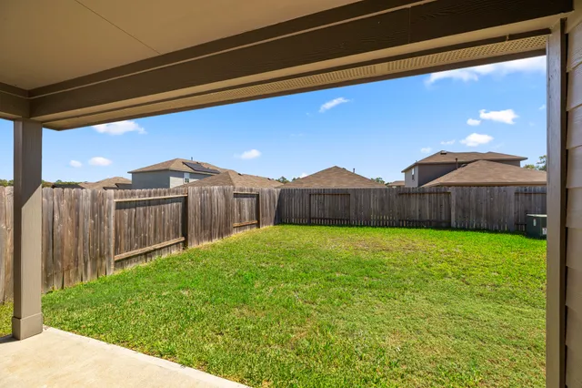 a view of a backyard with wooden fence