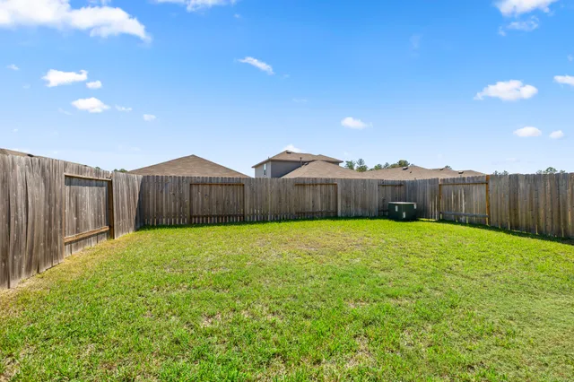 a view of a yard in front of a house with large trees